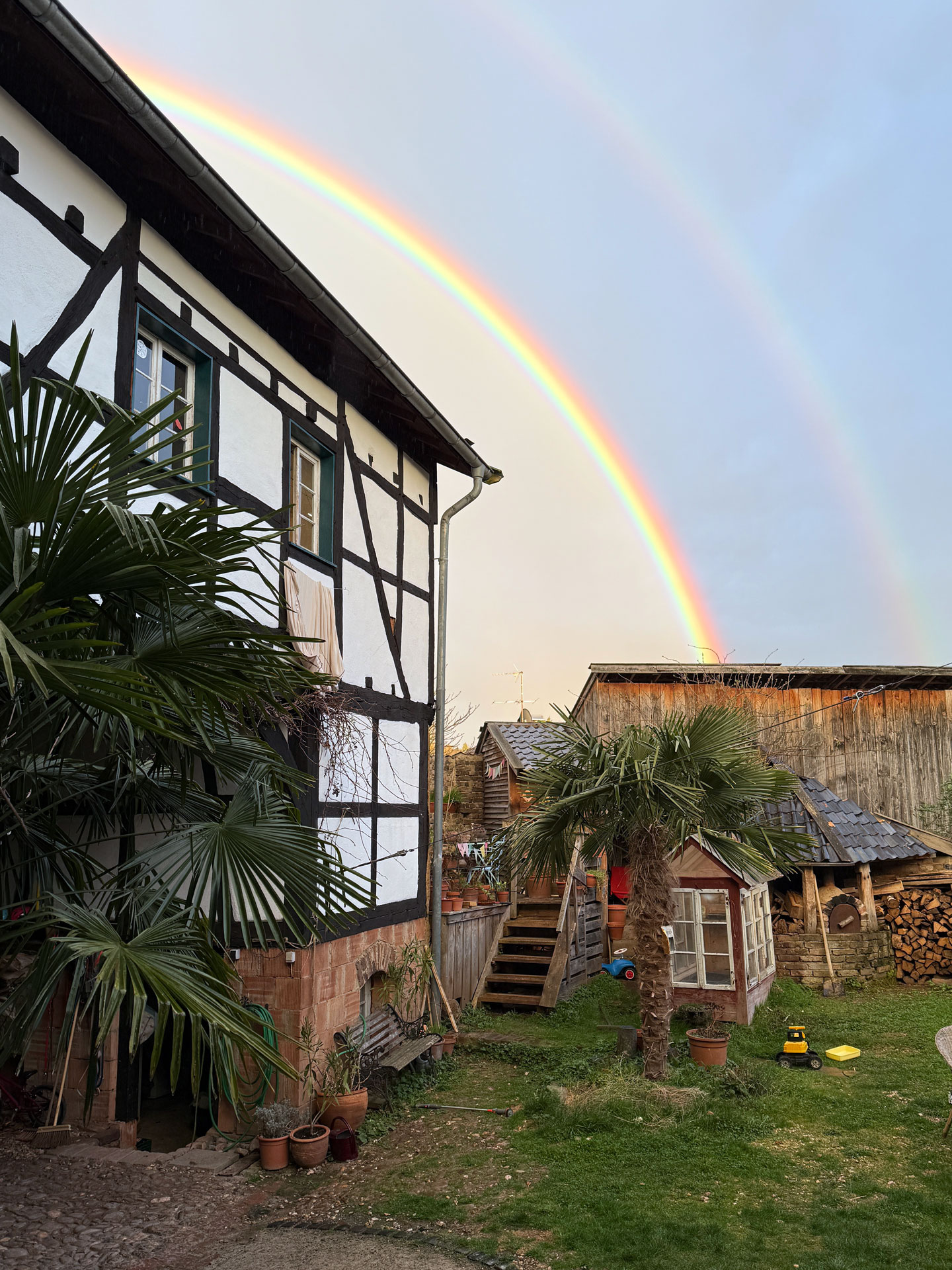 Denkmalgeschützter Fachwerkhof der Praxis Willems unter einem Regenbogen